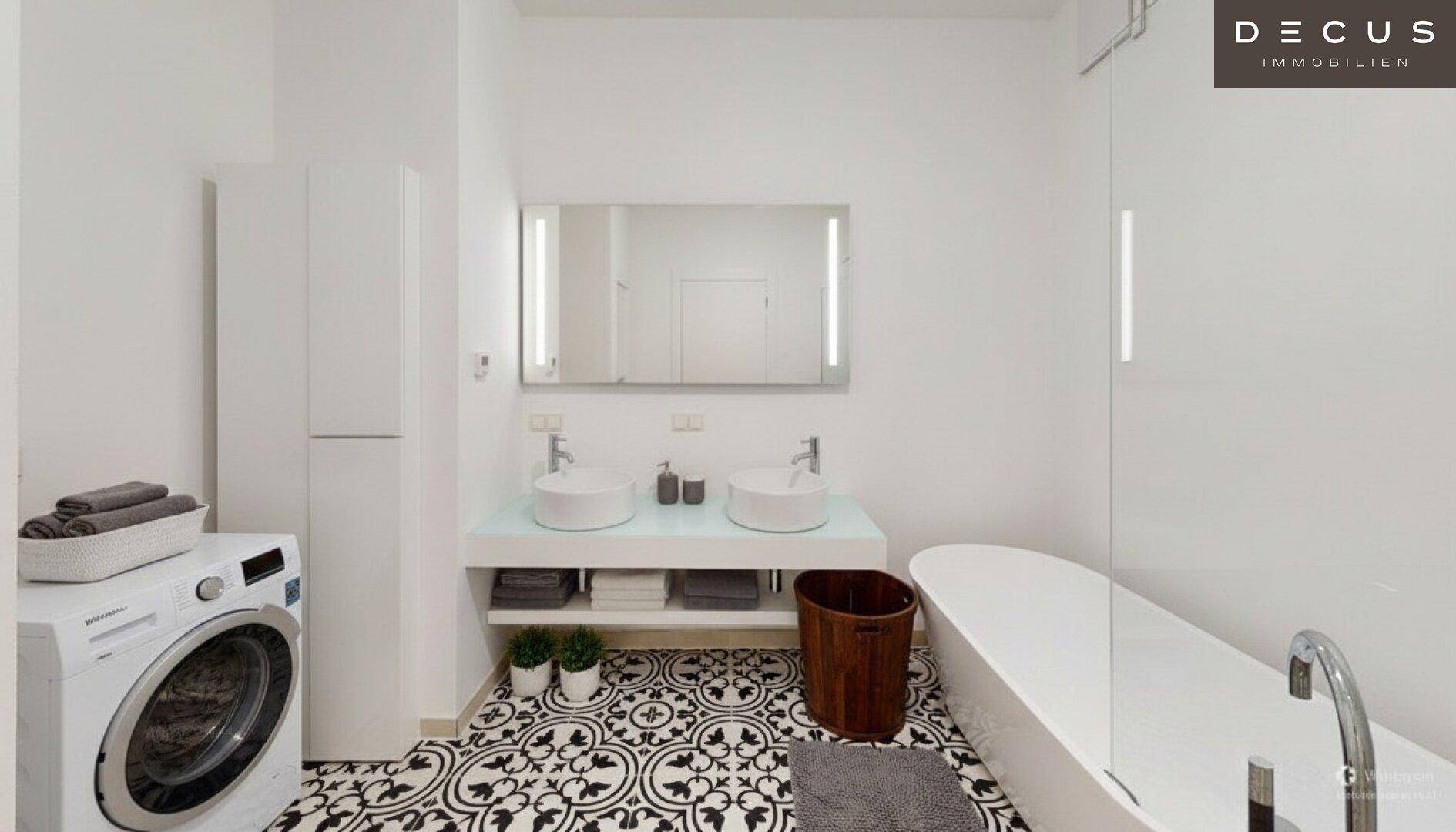 Modernes Badezimmer mit Doppelwaschbecken, freistehender Badewanne und Waschmaschine.