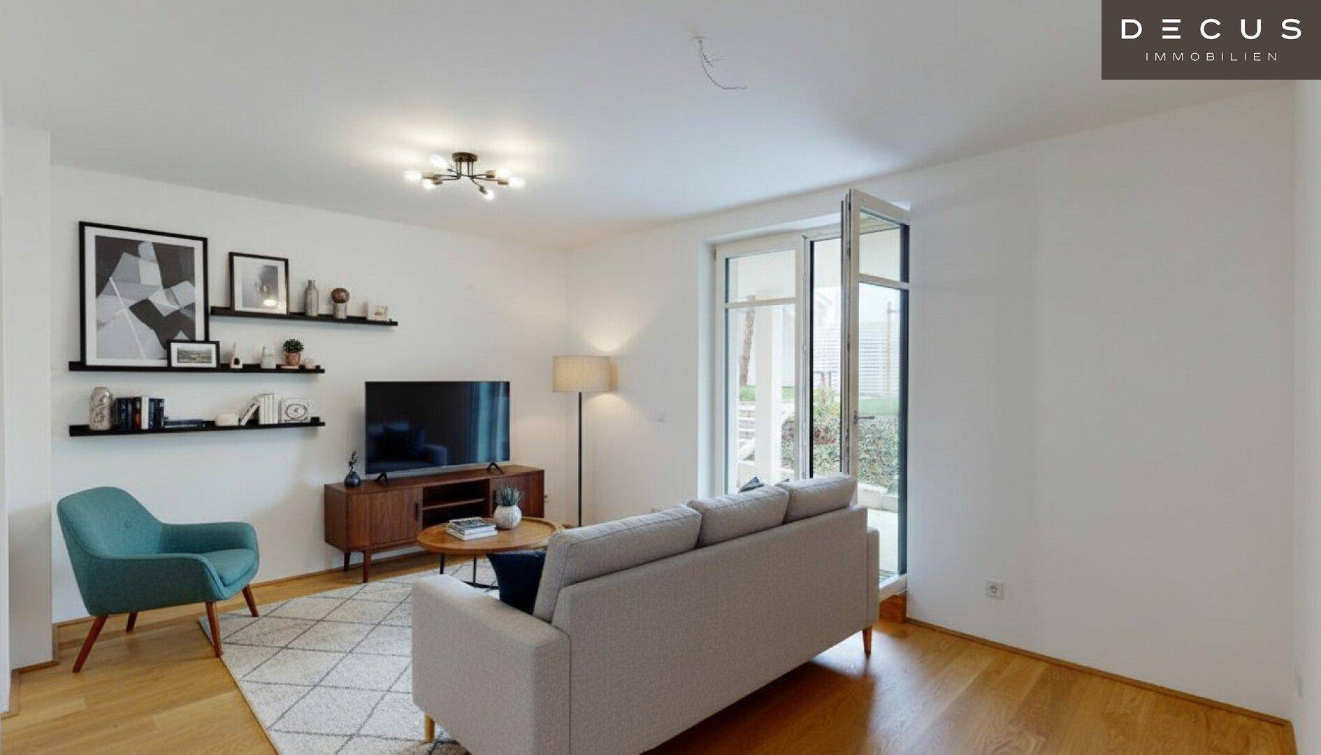 Gemütliches Wohnzimmer mit Holzboden, Sofa und Zugang zu einem Außenbereich mit Grünblick.
