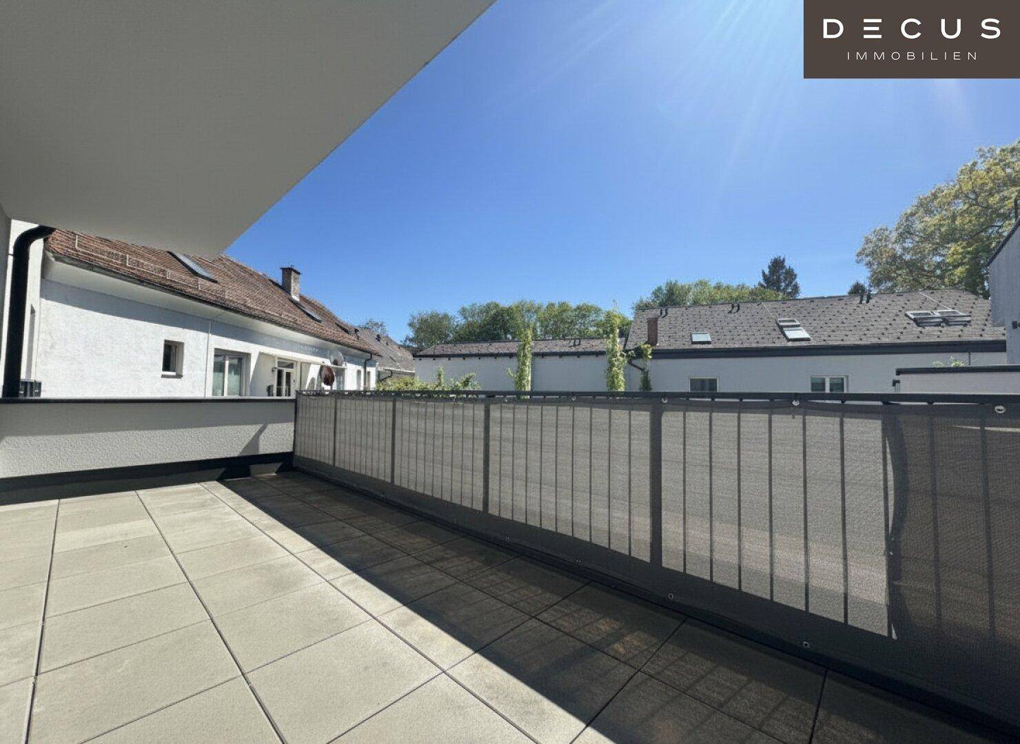 Geräumiger Balkon mit Fliesenboden und Blick auf die umliegenden Wohngebäude.