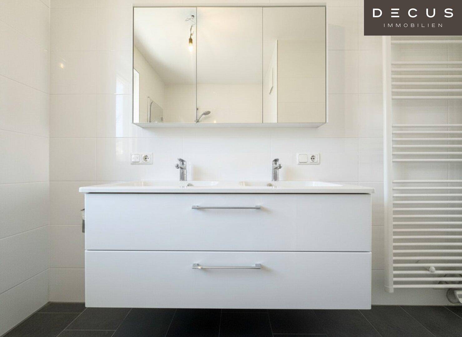 Doppelwaschbecken mit modernem Unterschrank und Spiegelschrank im Badezimmer.