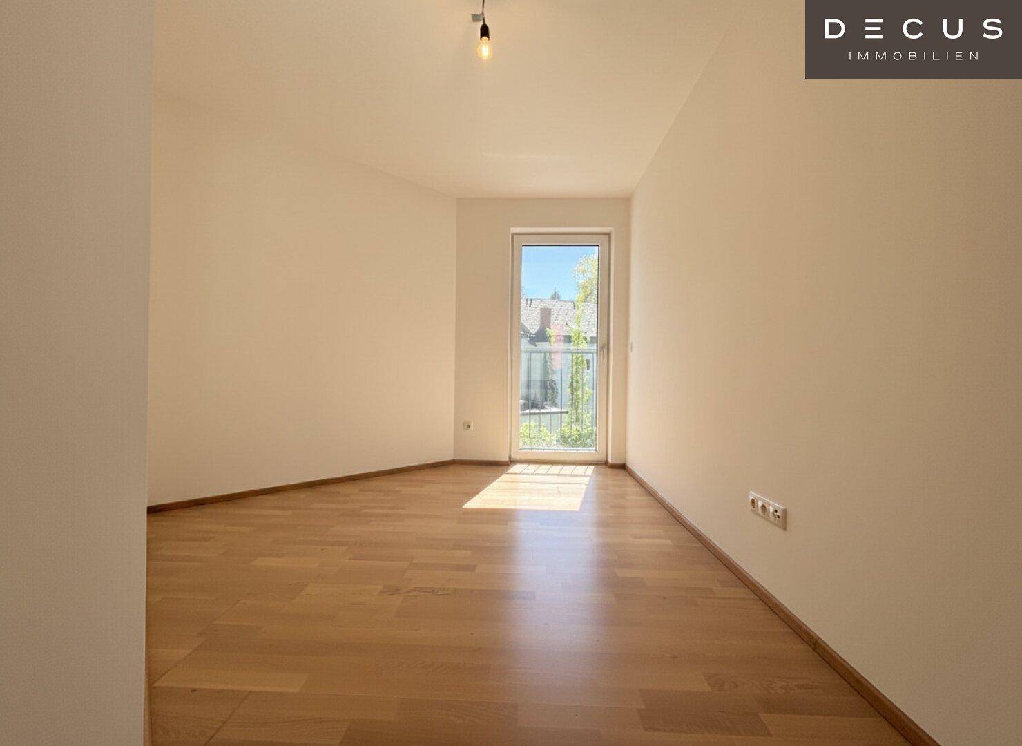Sonniger Raum mit Parkettboden und direktem Zugang zu einem französischen Balkon.