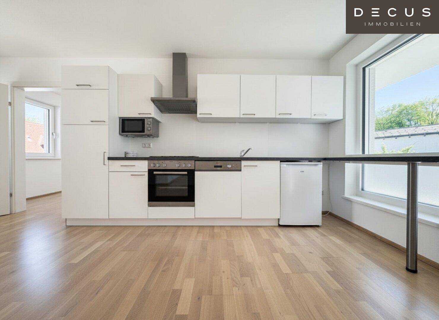 Moderne Einbauküche mit weißen Schränken, integrierten Geräten und viel Arbeitsfläche.