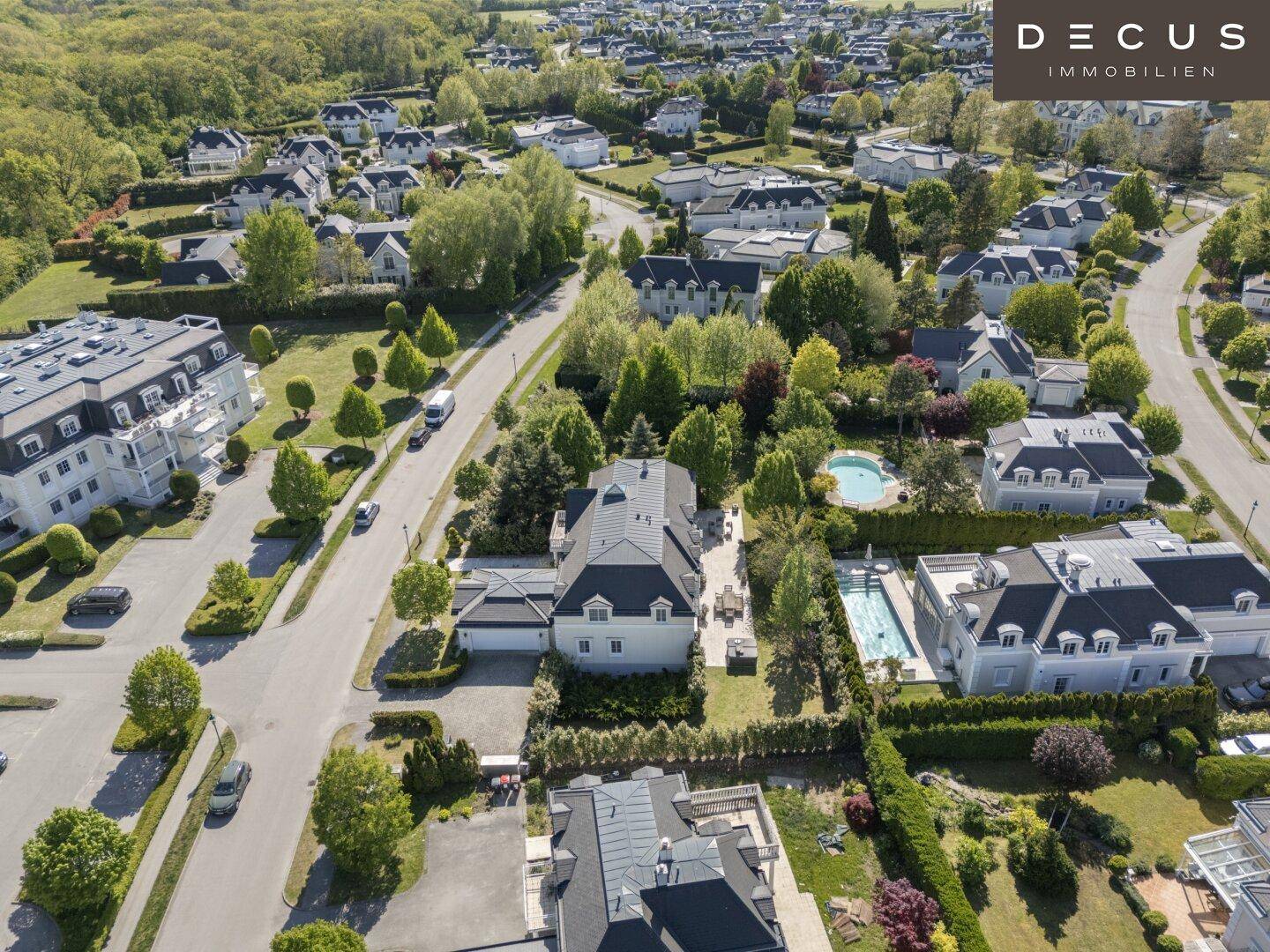 Luftaufnahme einer gehobenen Wohngegend mit vielen Häusern, Gärten und Pools.