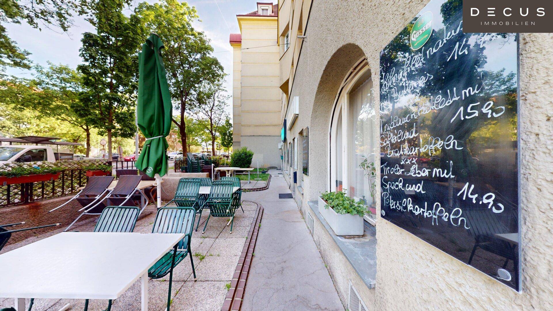 Außenterrasse mit Tischen und einer Kreidetafel, die Tagesgerichte anzeigt.