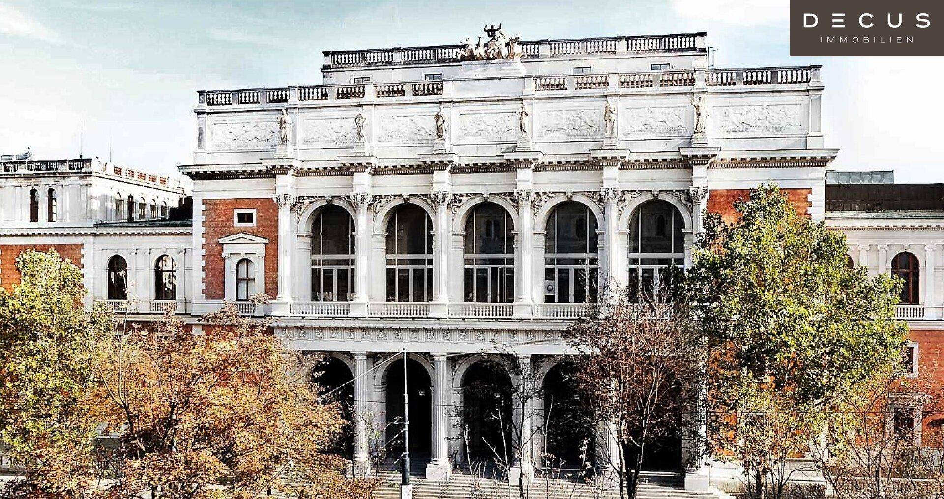 Majestätische Fassade eines historischen Gebäudes mit großen Bogenfenstern und Skulpturen.