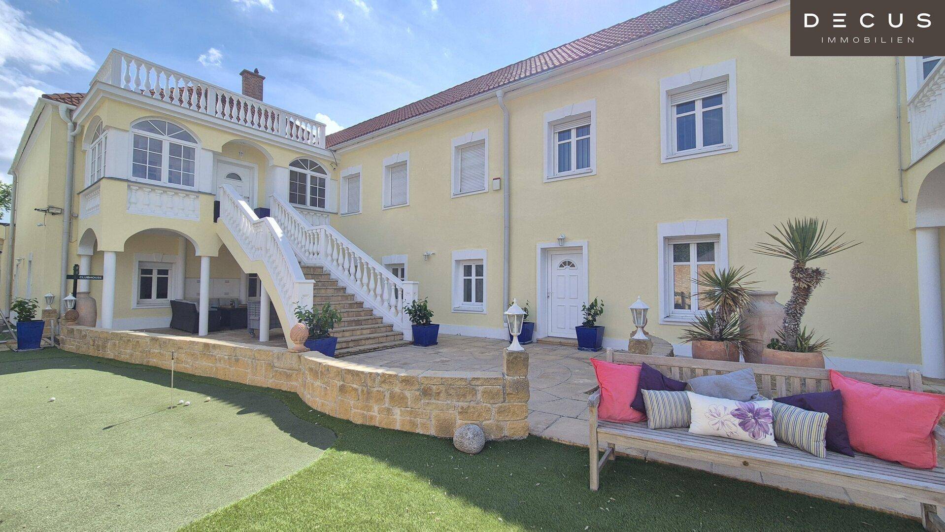 Charmantes Anwesen mit großer Außentreppe, gepflegtem Gartenbereich und gemütlicher Sitzbank mit Kissen.