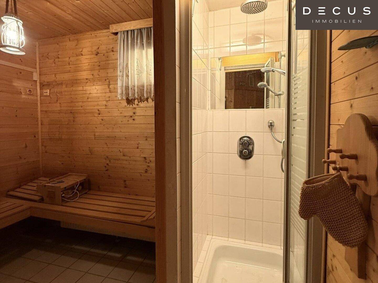 Sauna und angrenzende Dusche mit weißen Fliesen, ideal für Wellness zu Hause.