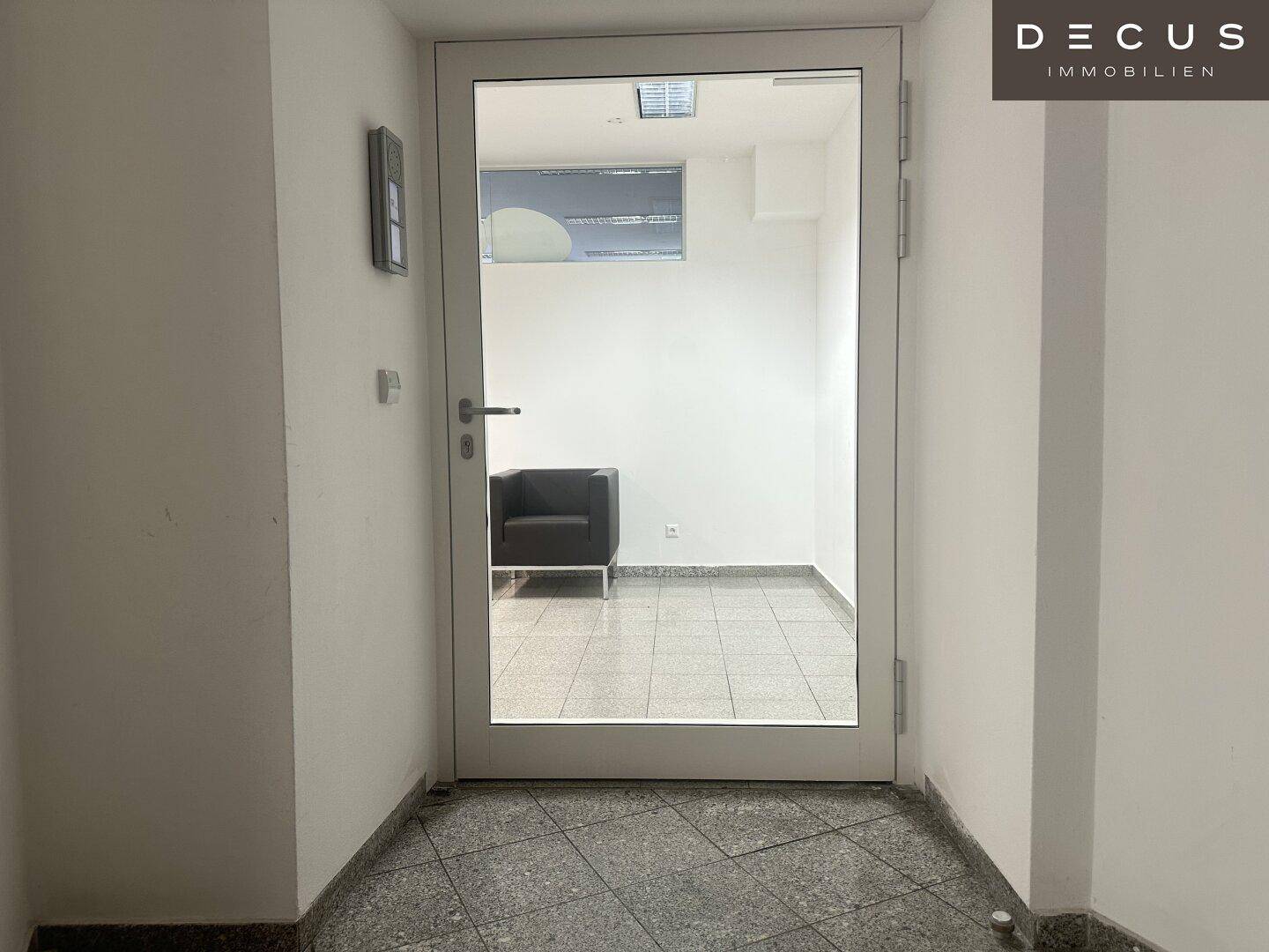 Eingangstür zu einem Büro oder Wartebereich mit Glasfront und Blick auf den Innenraum.