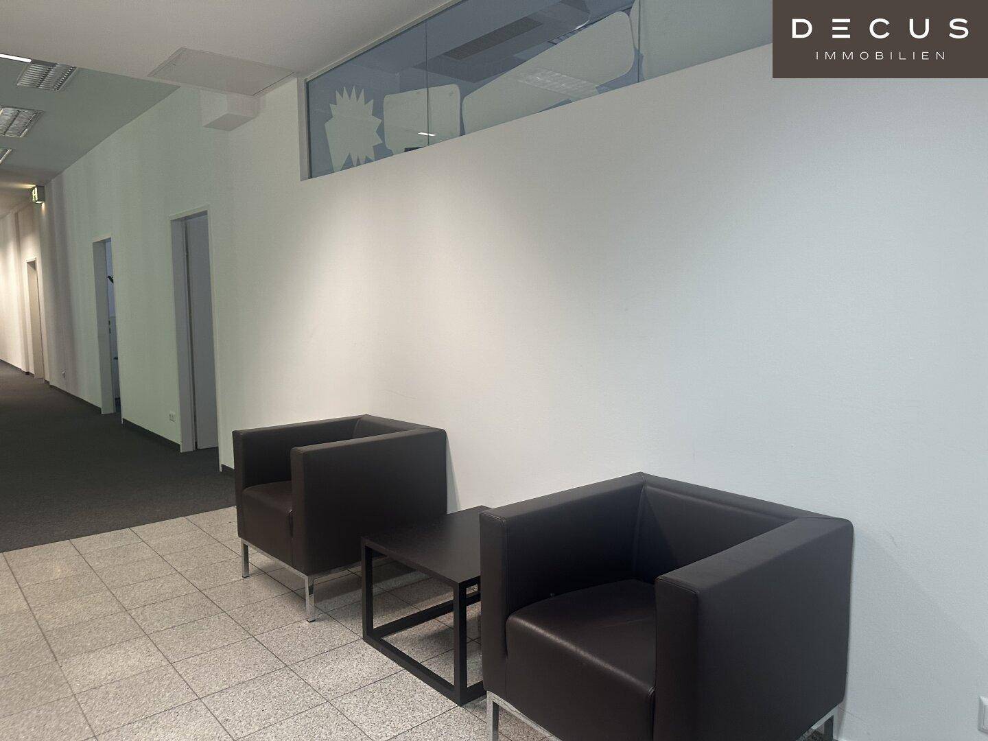 Empfangsbereich mit zwei bequemen Ledersesseln und einem kleinen Beistelltisch in modernem Design.