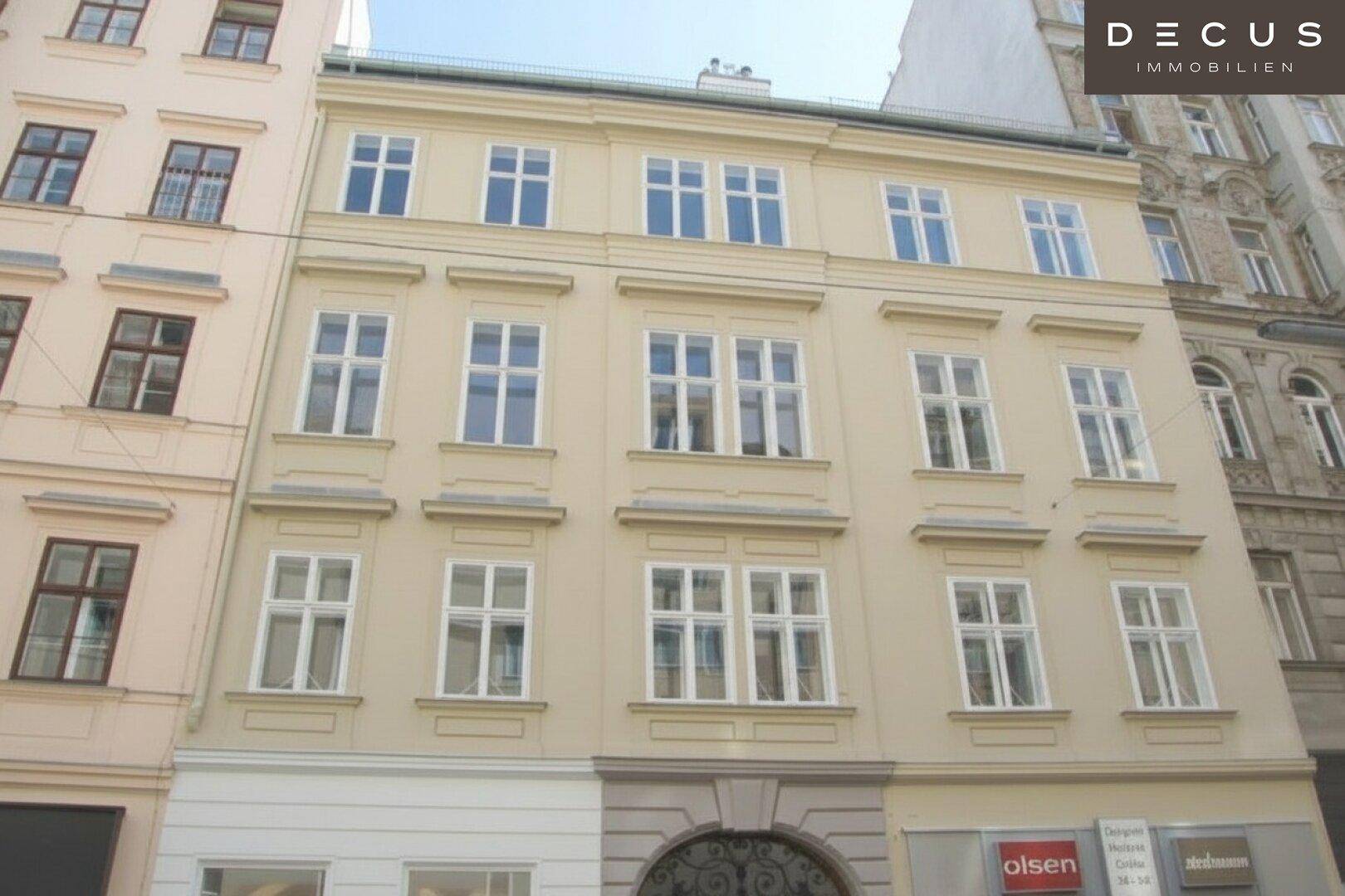 Klassische Fassade eines Mehrfamilienhauses mit vielen großen Fenstern und einer gepflegten Erscheinung in der Stadt.