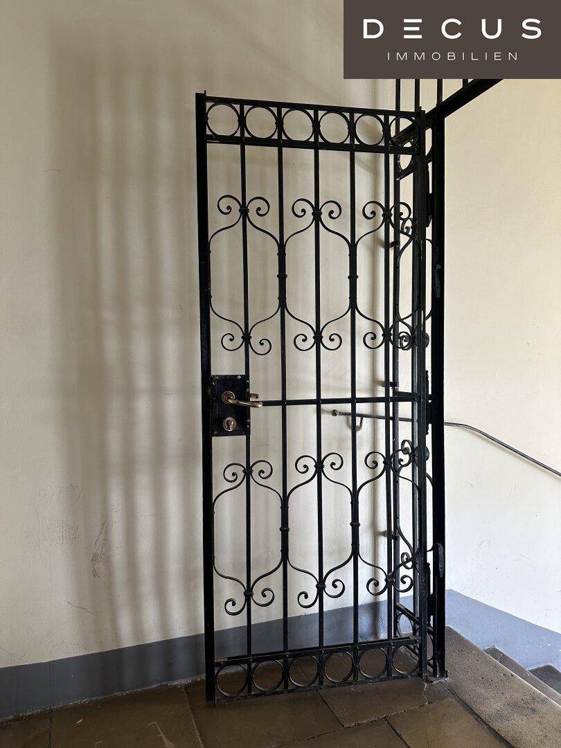 Dekoratives schmiedeeisernes Tor im Treppenhaus, das den Zugang zu einem Bereich sichert.
