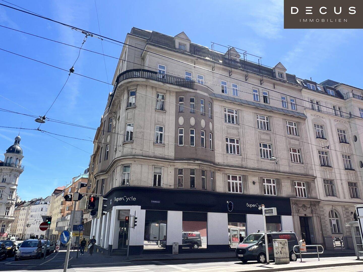 Eckgebäude mit klassischer Architektur, Geschäften und belebter Straßenansicht.
