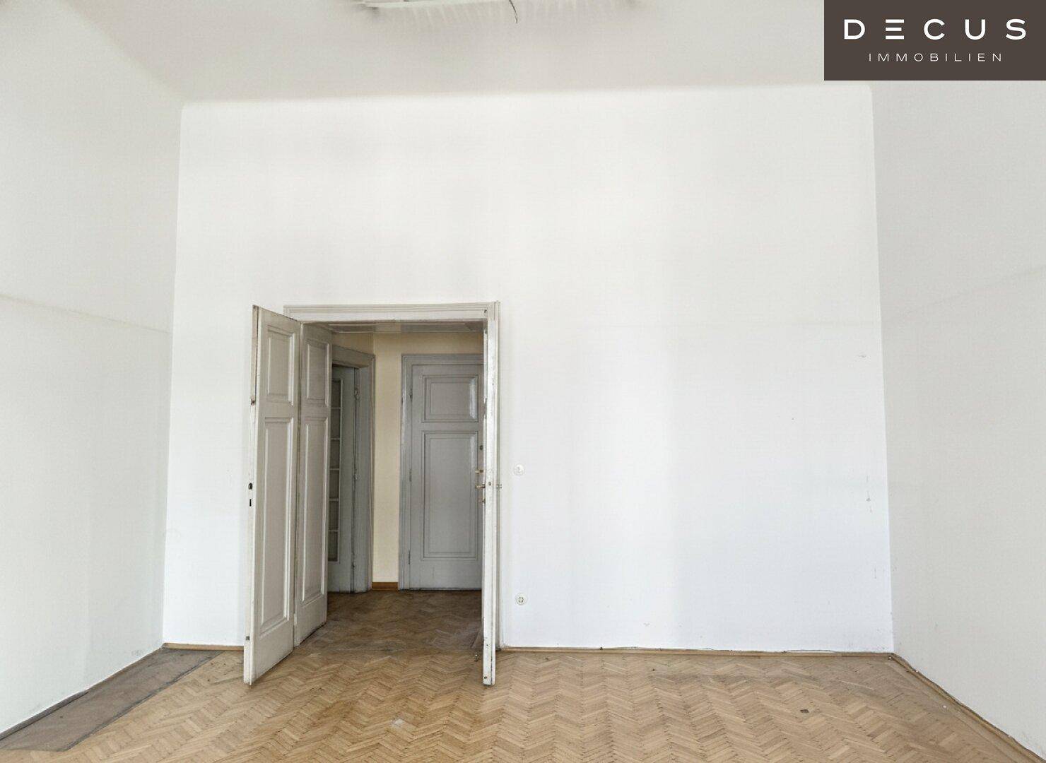 Leerer Raum mit hohen Decken und Fischgrätparkett, bereit zur individuellen Gestaltung.
