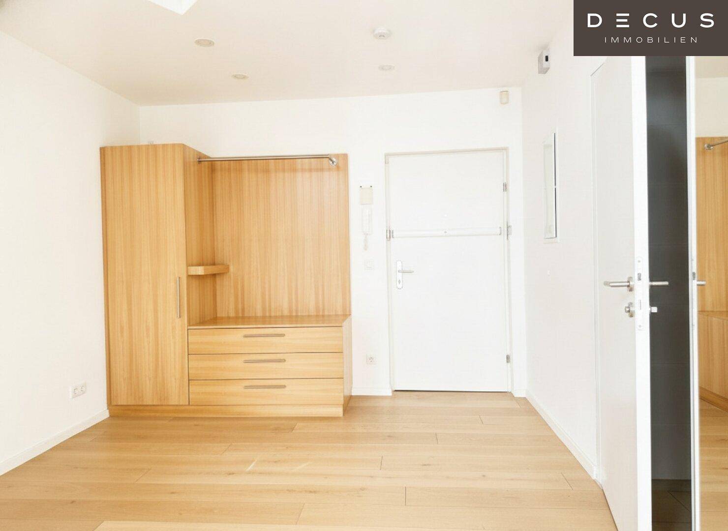 Heller Flur mit Holzboden und einem modernen Einbauschrank aus hellem Holz.
