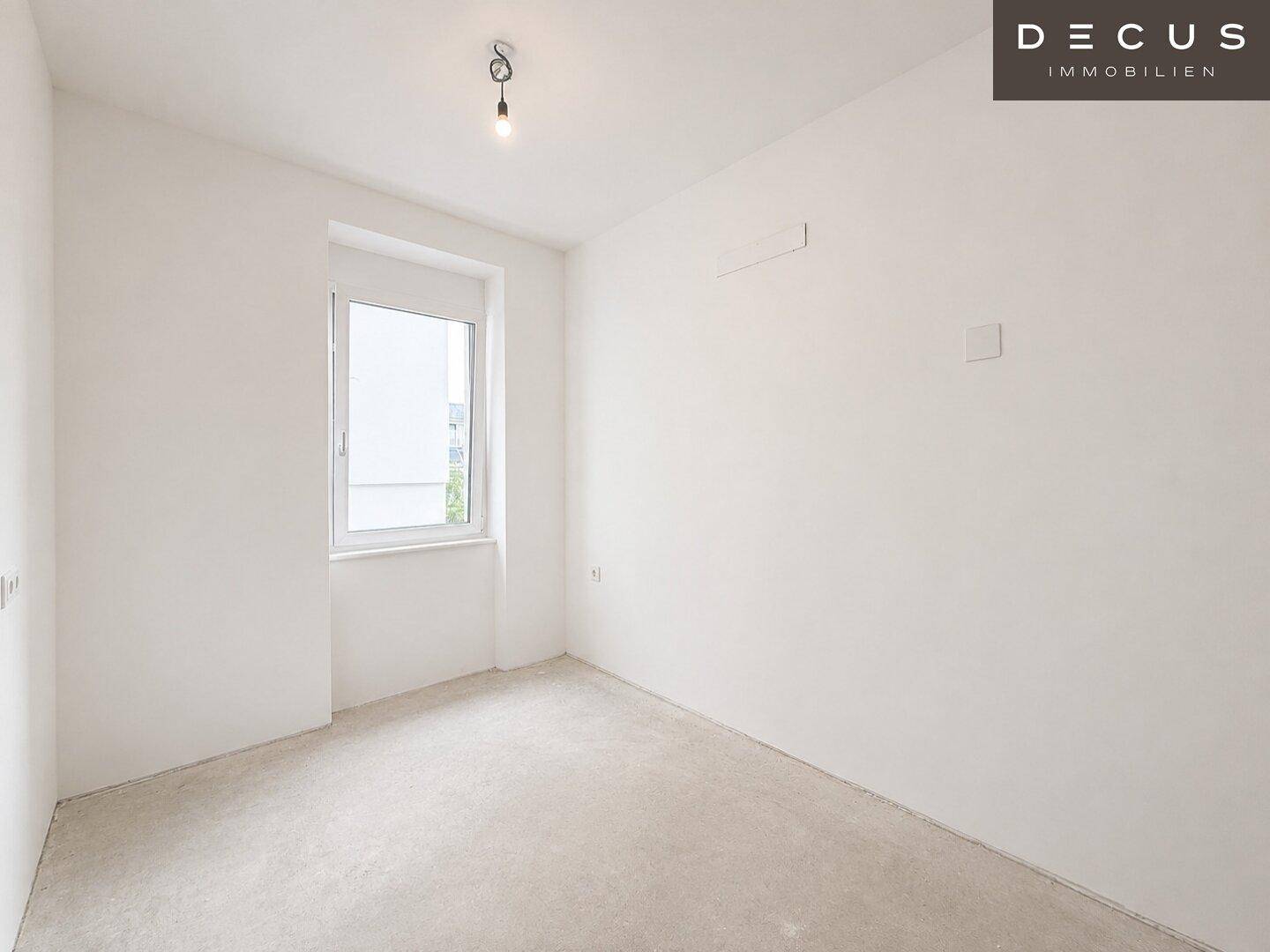 Leeres Schlafzimmer mit einem Fenster und unfertigem Bodenbelag.