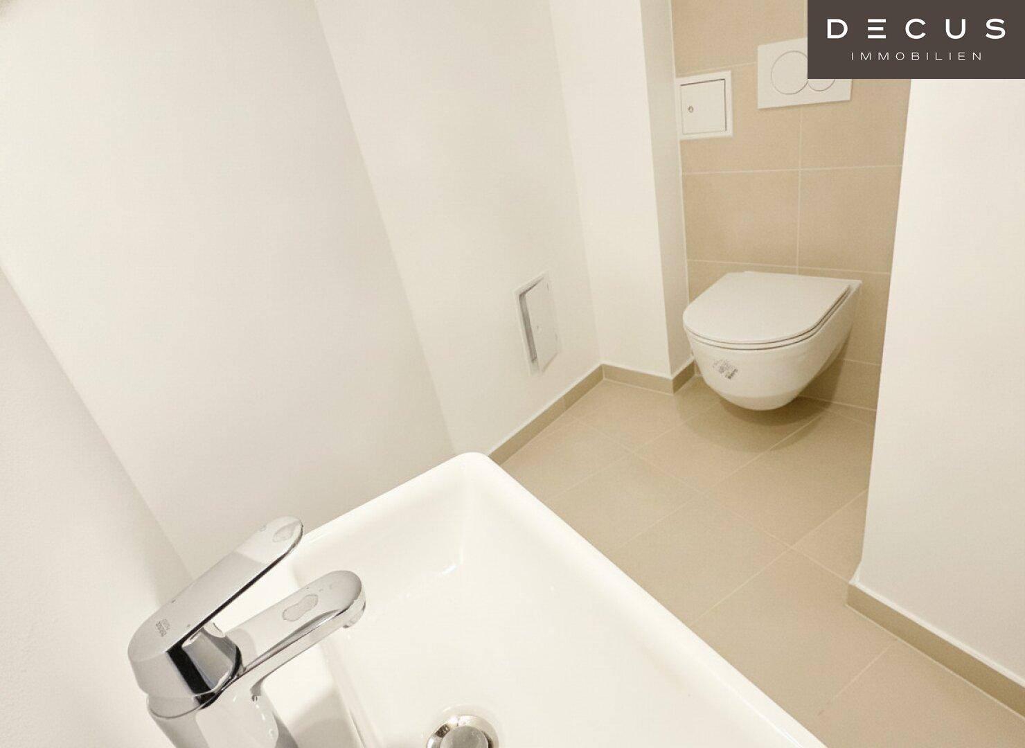 Modernes Gäste-WC mit beigefarbenen Fliesen, wandhängender Toilette und rechteckigem Waschbecken.