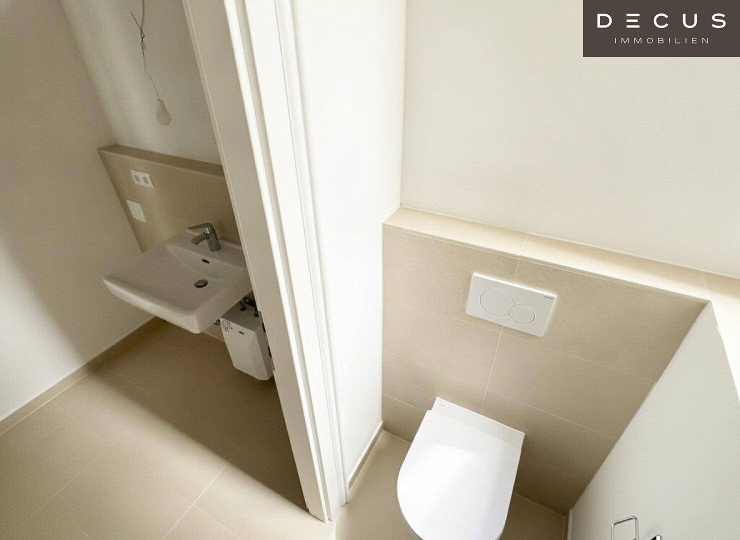 Helles Gäste-WC mit beigefarbenen Fliesen, wandhängender Toilette und modernem Waschbecken.