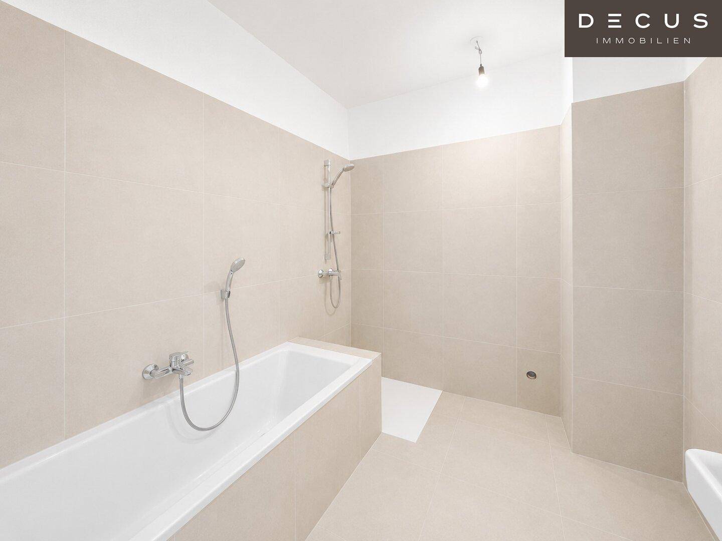 Helles Badezimmer mit Badewanne, Duschanschluss und beigen Fliesen.