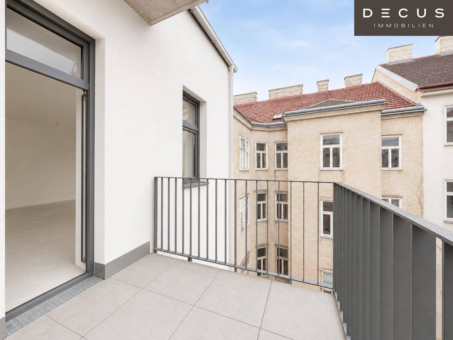 Kleiner Balkon mit Fliesenboden und Metallgeländer mit Blick auf die Nachbargebäude.
