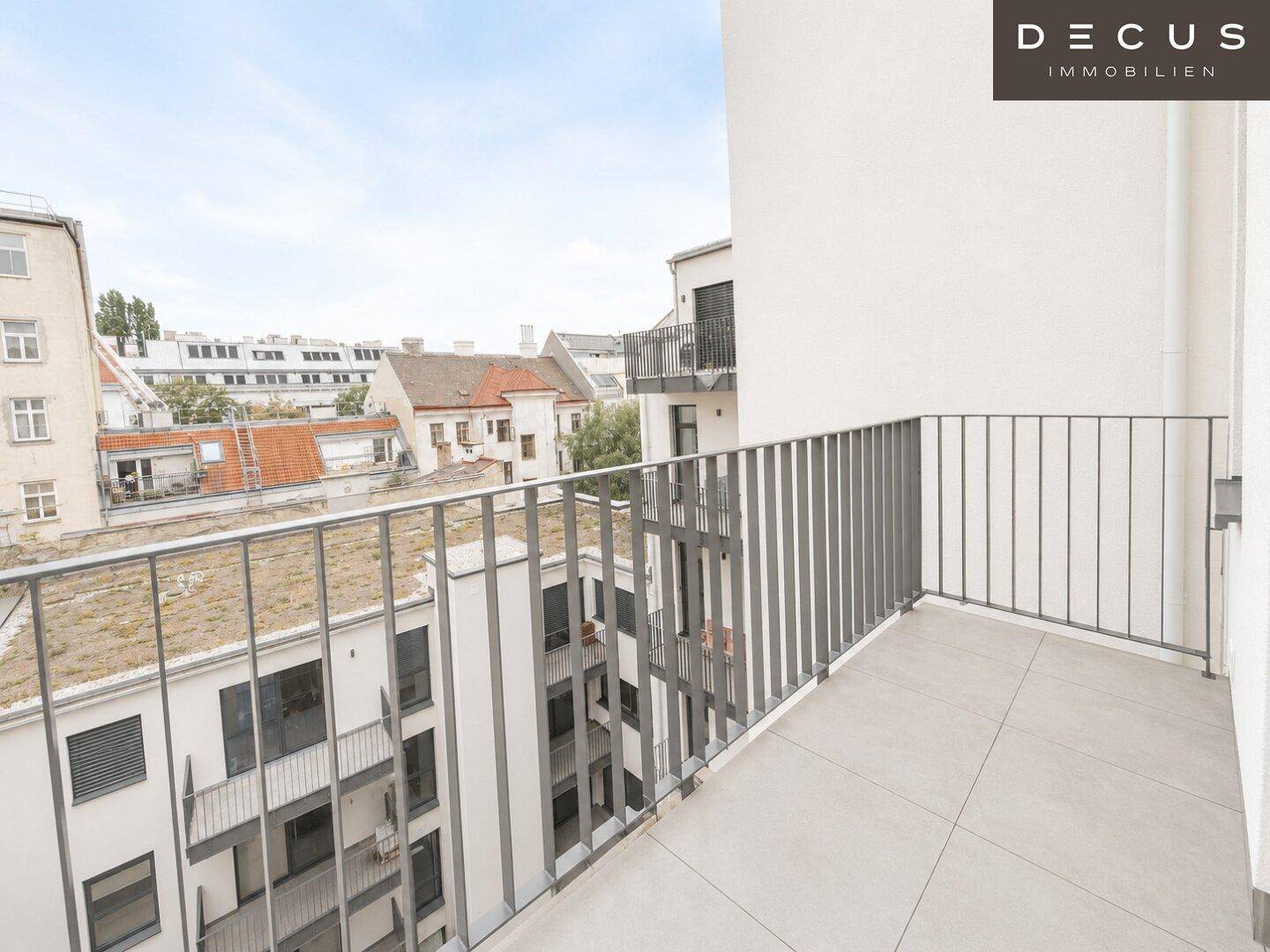 Geräumiger Balkon mit Fliesenboden und Metallgeländer mit Blick auf die Umgebung.