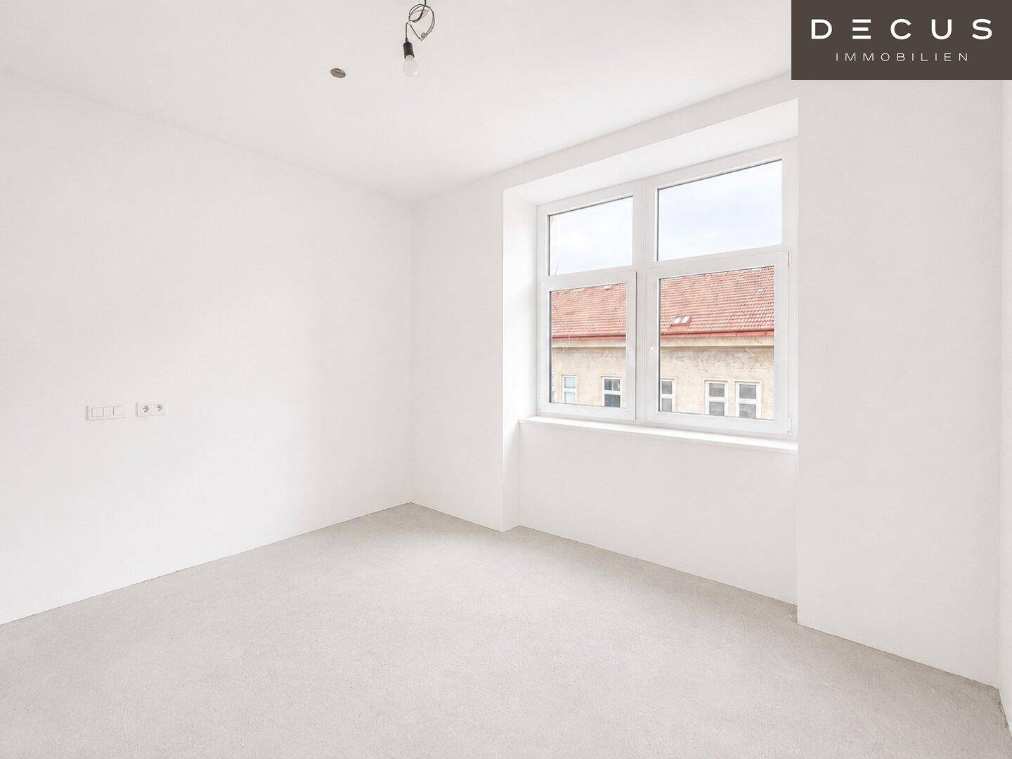 Leeres Zimmer mit großen Fenstern und Parkettboden, vielseitig nutzbar als Schlaf- oder Arbeitszimmer.