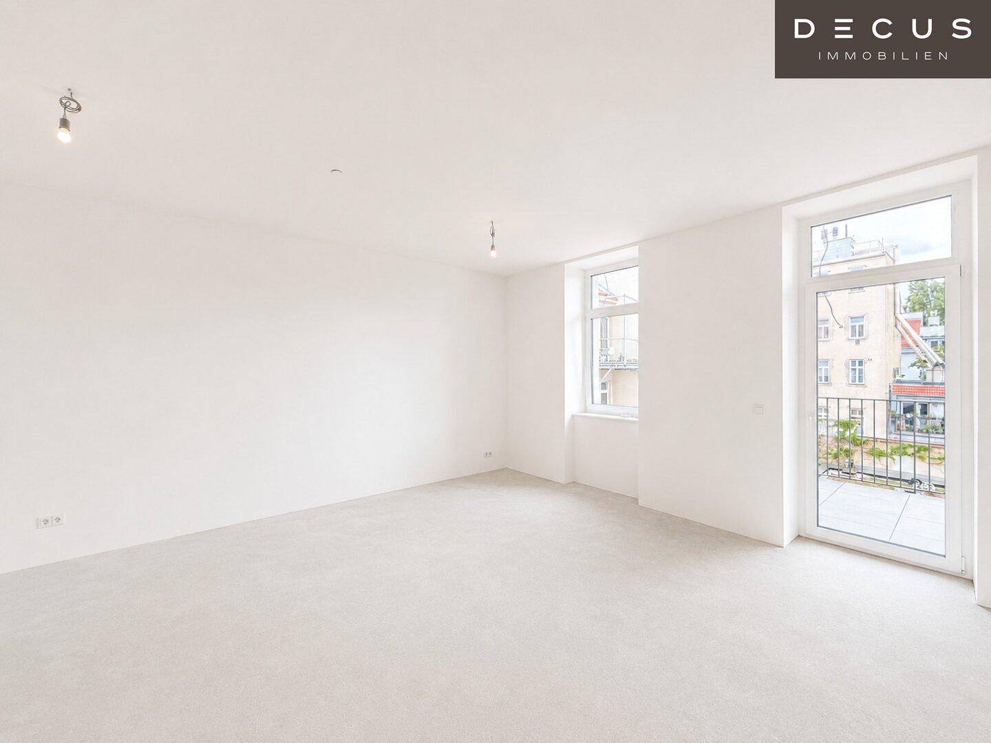Geräumiges, unmöbliertes Wohnzimmer mit hellen Wänden, Parkettboden und Zugang zum Balkon.