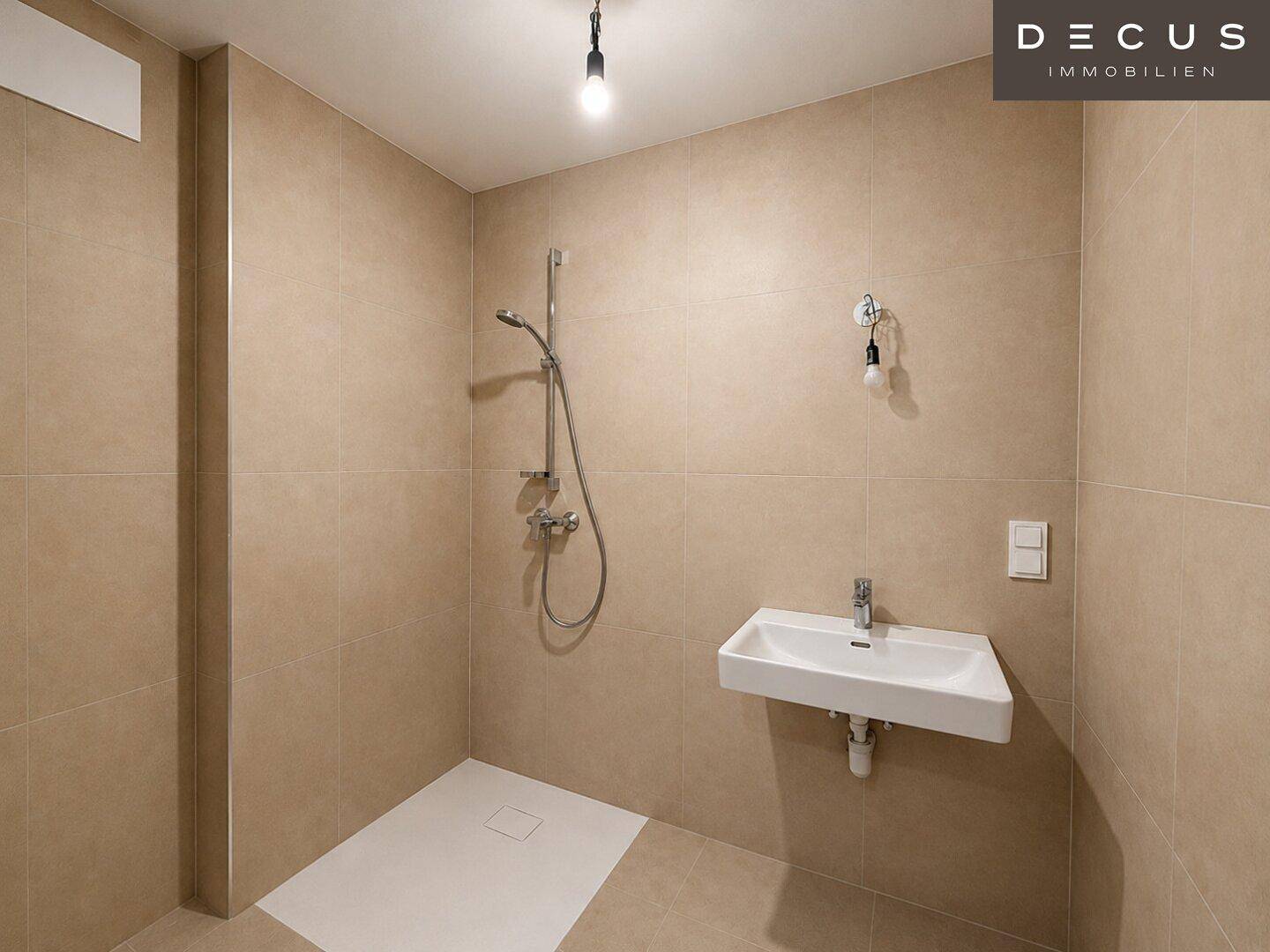 Unmöbliertes Badezimmer mit begehbarer Dusche und Waschbecken an der Wand.
