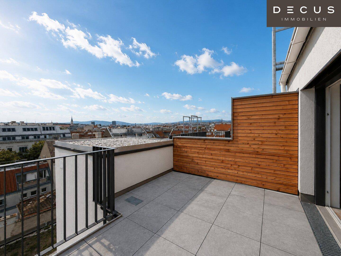 Helle Dachterrasse mit Holzverkleidung und weitem Blick über die Stadtlandschaft.
