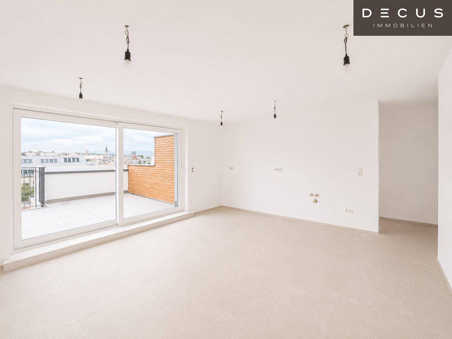 Unmöblierter Küchenbereich mit Fliesenboden und großem Zugang zur Terrasse.