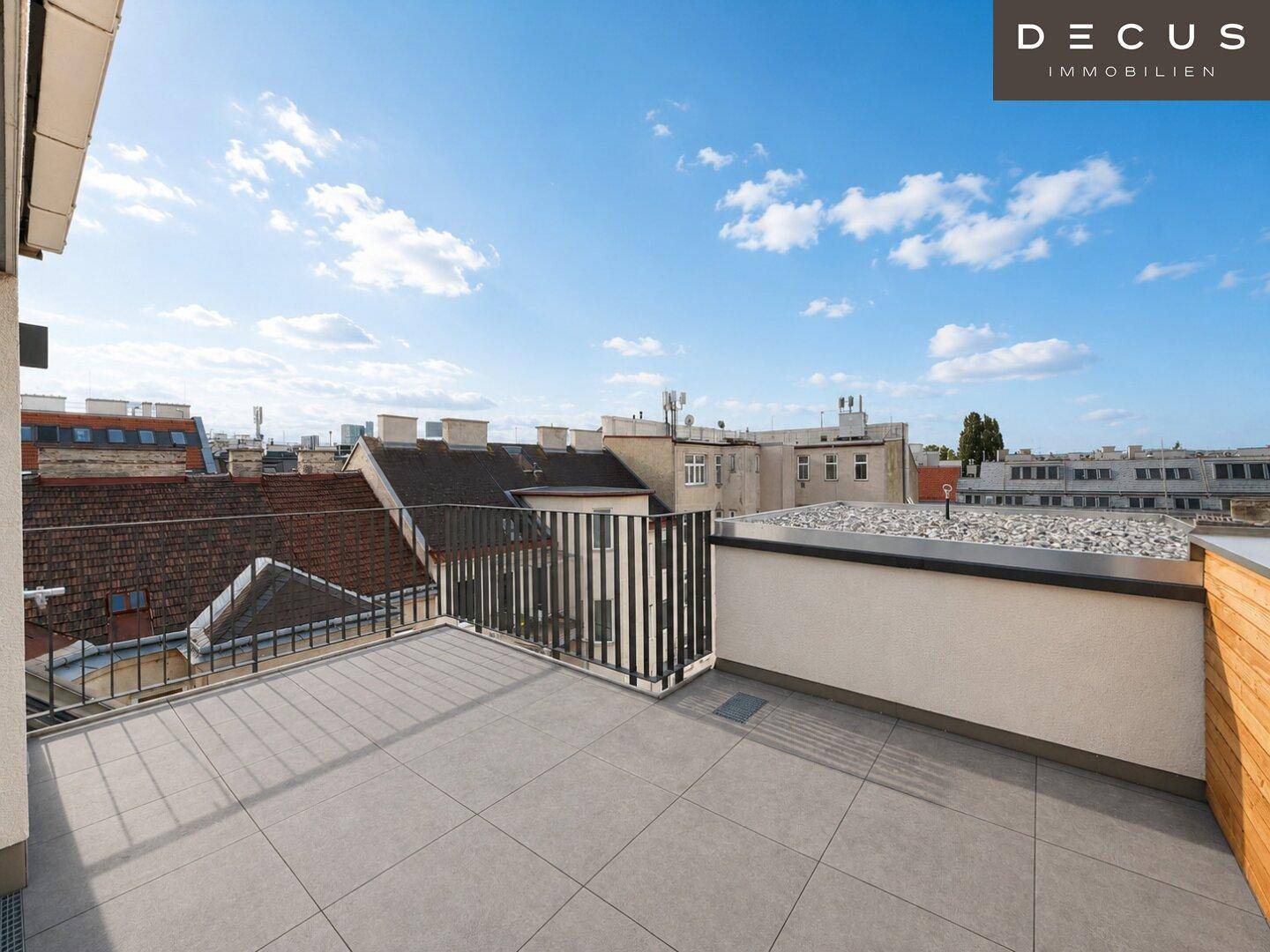 Geräumige Dachterrasse mit Fliesenboden und Blick auf die umliegenden Dächer.