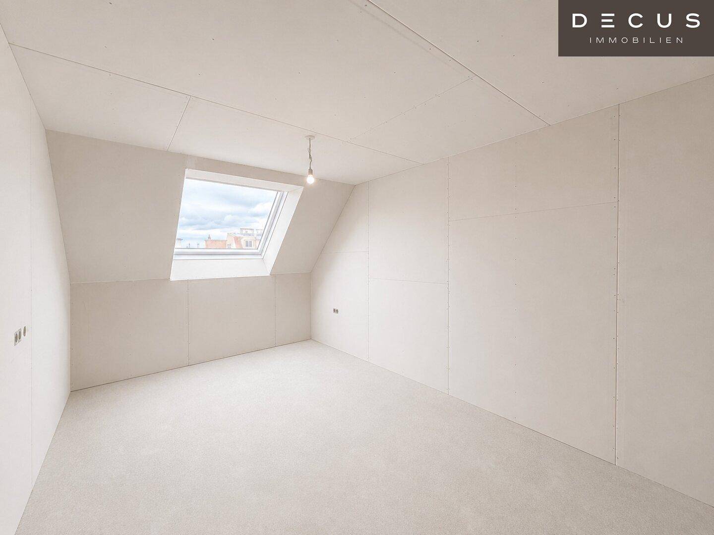 Unmöblierter Raum im Dachgeschoss mit Dachfenster und schrägen Wänden.