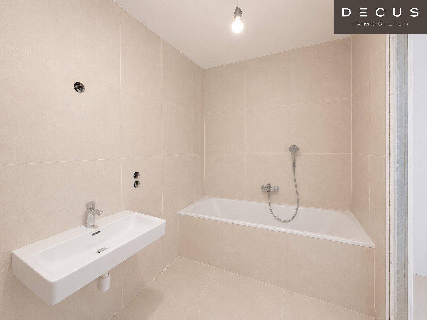 Unfertiges Badezimmer mit Badewanne und Waschbecken, bereit für die Endmontage der Armaturen.