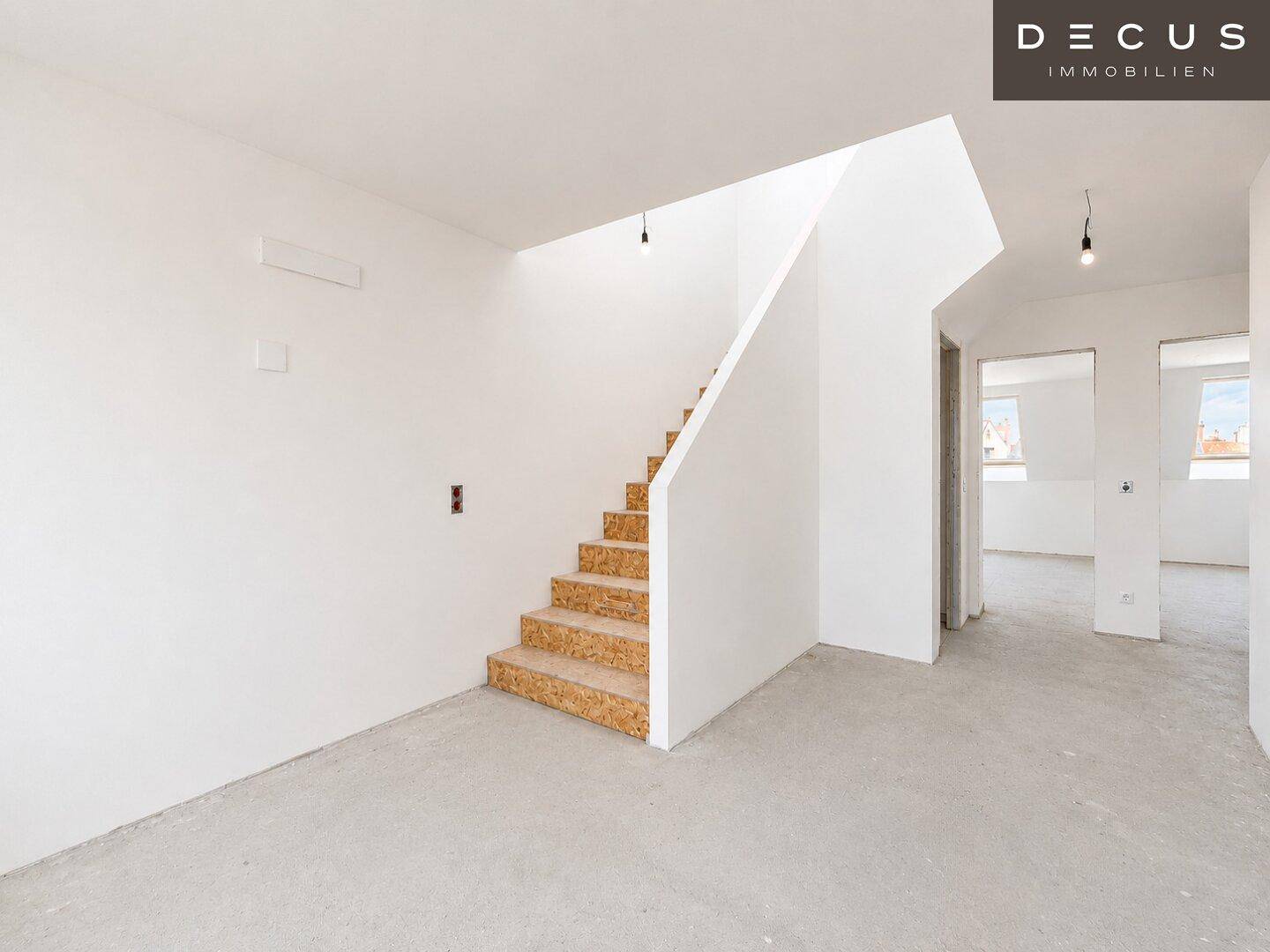 Unfertiger Eingangsbereich mit Treppe, bereit für den Innenausbau und die Bodengestaltung.