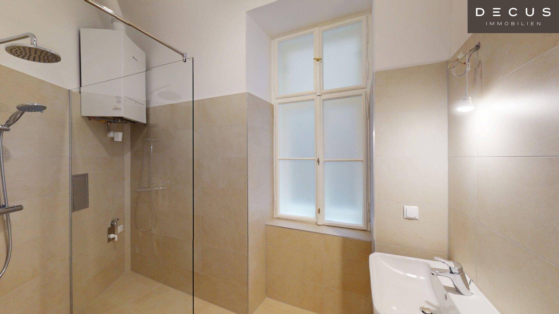 Modernes Badezimmer mit begehbarer Dusche, beigefarbenen Fliesen und einem Fenster für Tageslicht.