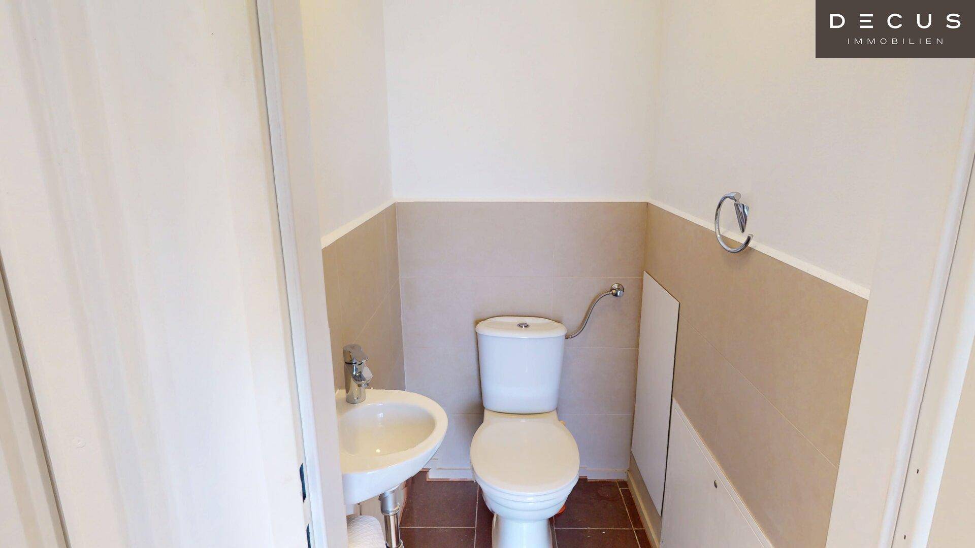 Kleines Gäste-WC mit Waschbecken und Toilette in schlichtem Design.