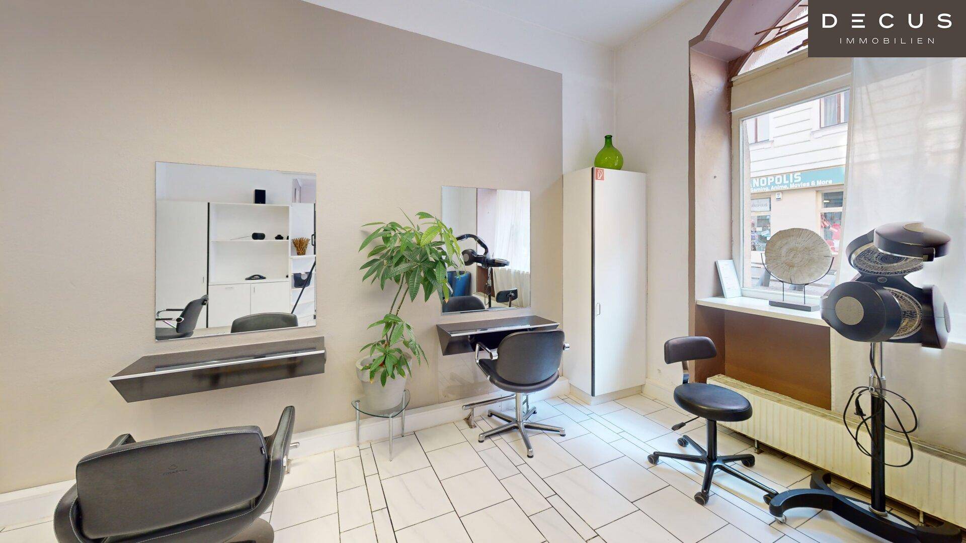 Styling-Station in einem Friseursalon mit großem Spiegel und Fenster zur Straße.