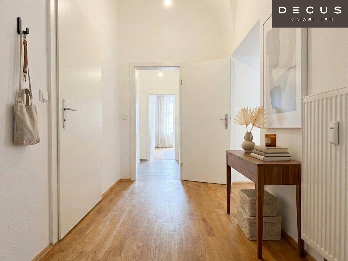 Heller Flur mit Holzboden, weißen Wänden und einem eleganten Konsolentisch.