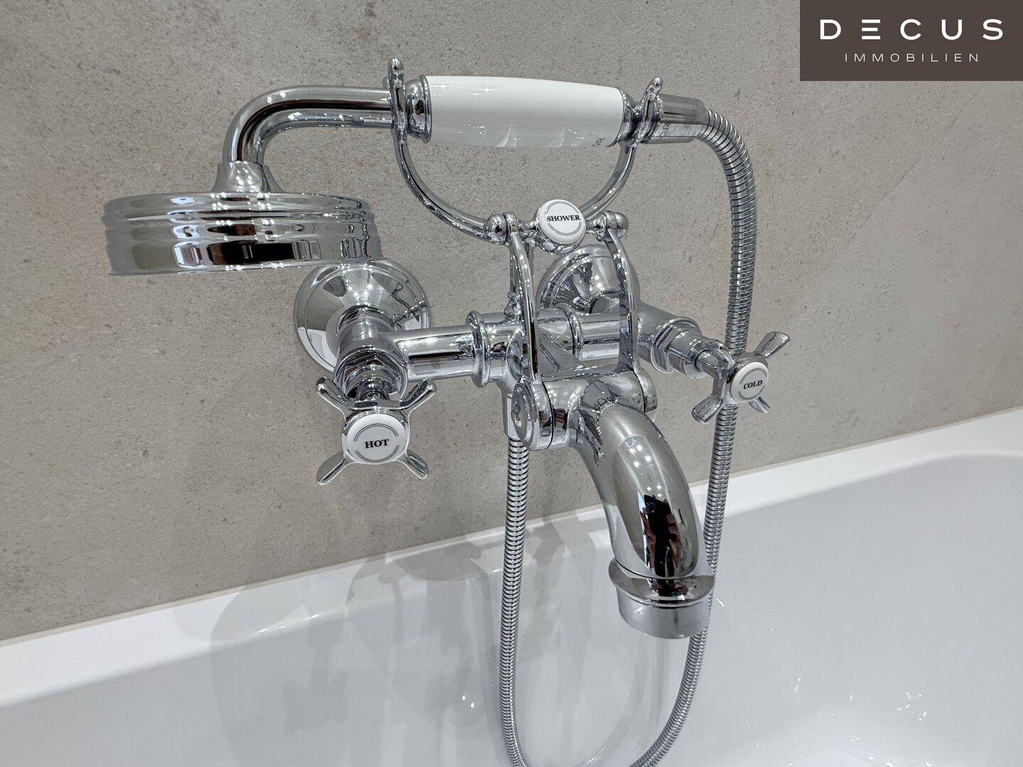 Klassische Badewannenarmatur mit integrierter Handbrause in glänzendem Chrom-Design.