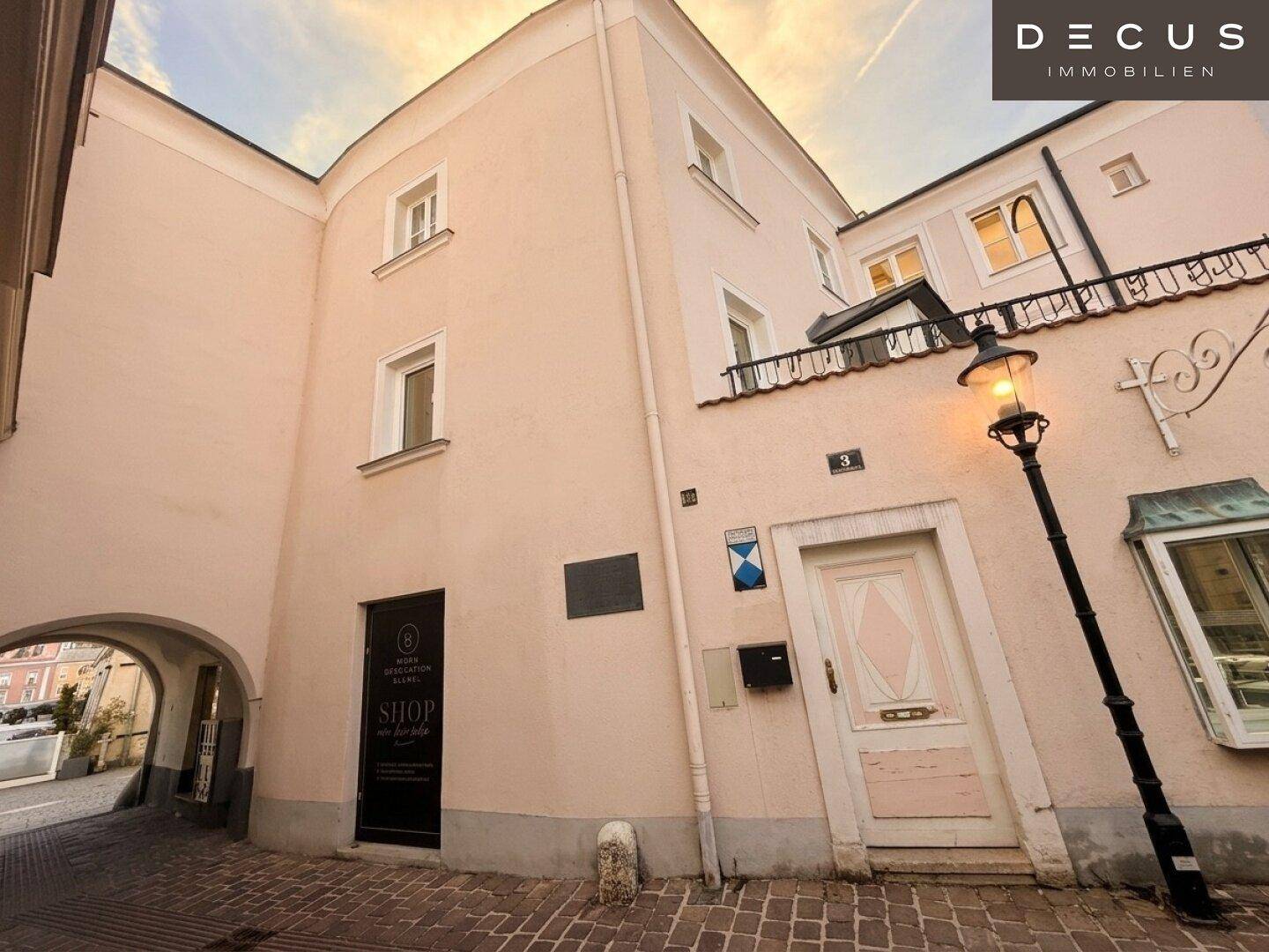 Historische Gasse mit gepflastertem Boden und traditioneller Straßenlaterne.