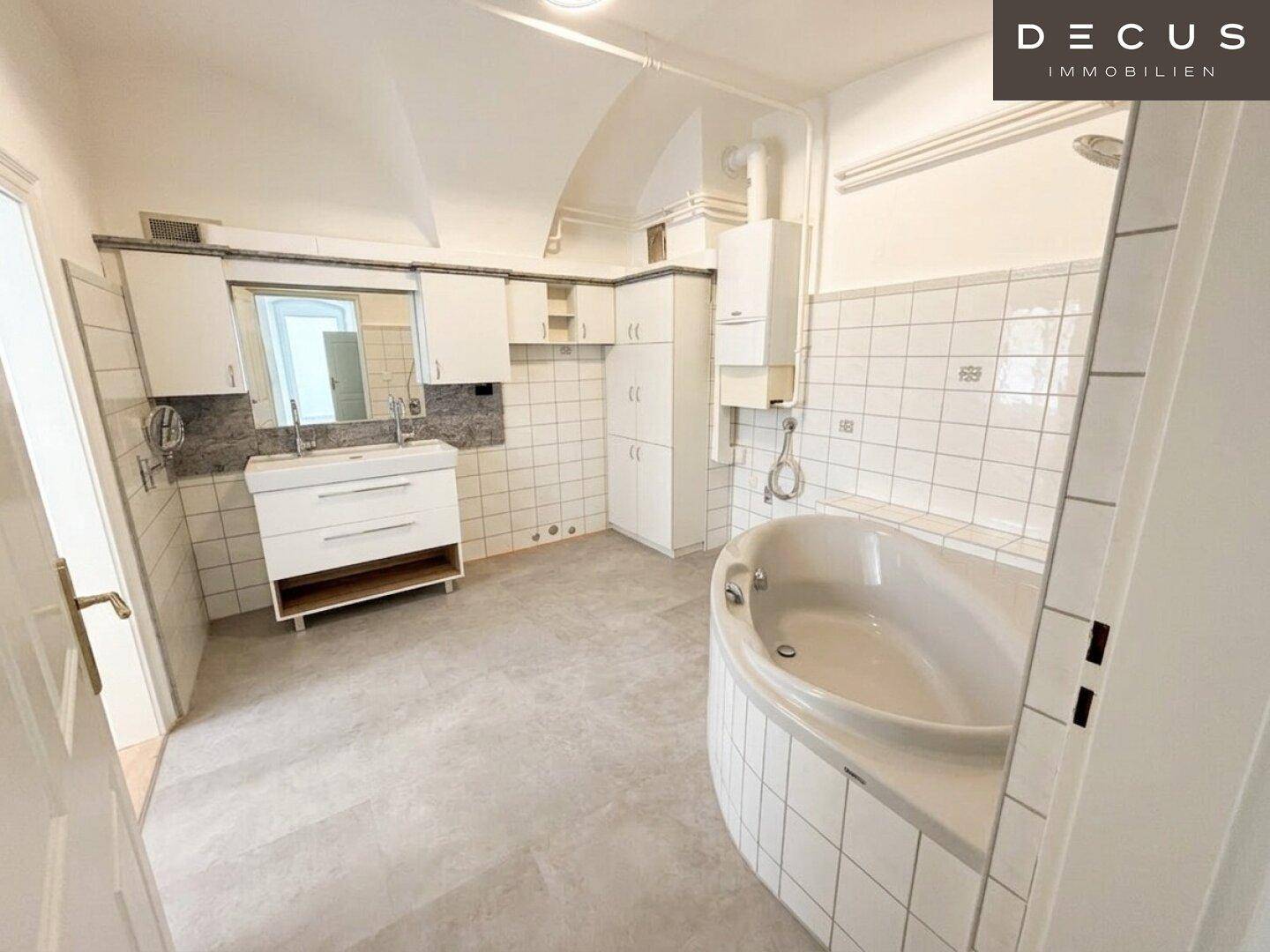 Geräumiges Badezimmer mit Eckbadewanne, Fliesenboden und weißen Wandfliesen.