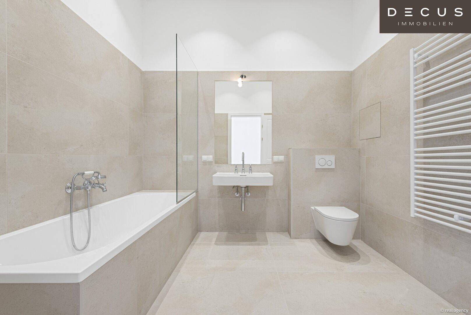 Modernes Badezimmer mit Badewanne, Wand-WC und beheiztem Handtuchhalter.