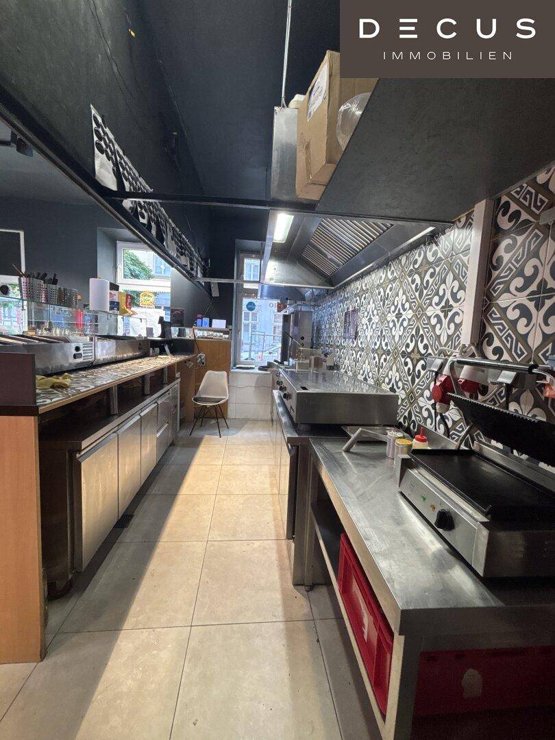Professionelle Küche eines Schnellrestaurants mit Edelstahloberflächen und Kochgeräten.