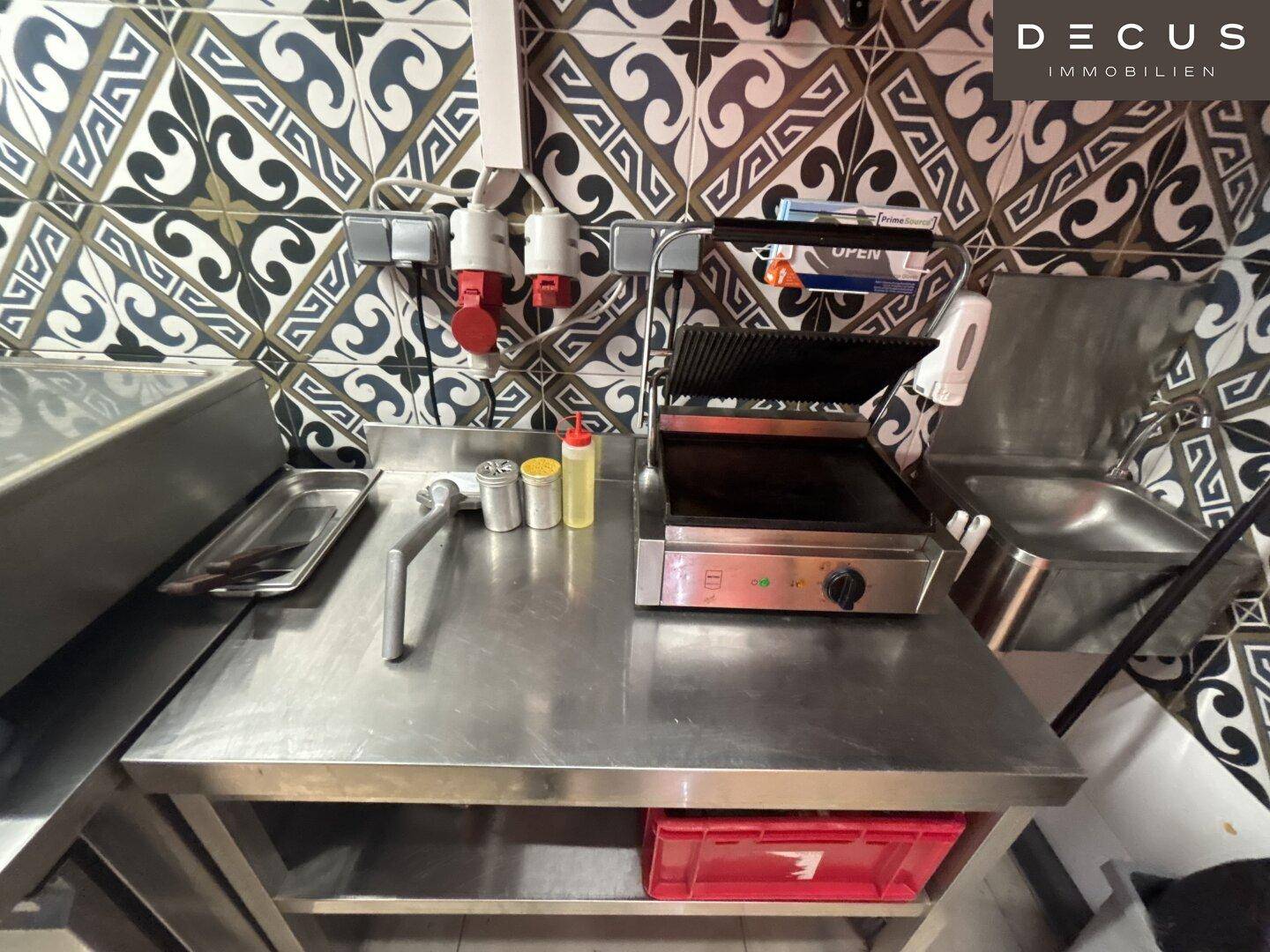 Arbeitsplatz in der Küche mit Toaster, Spüle und Edelstahloberfläche.