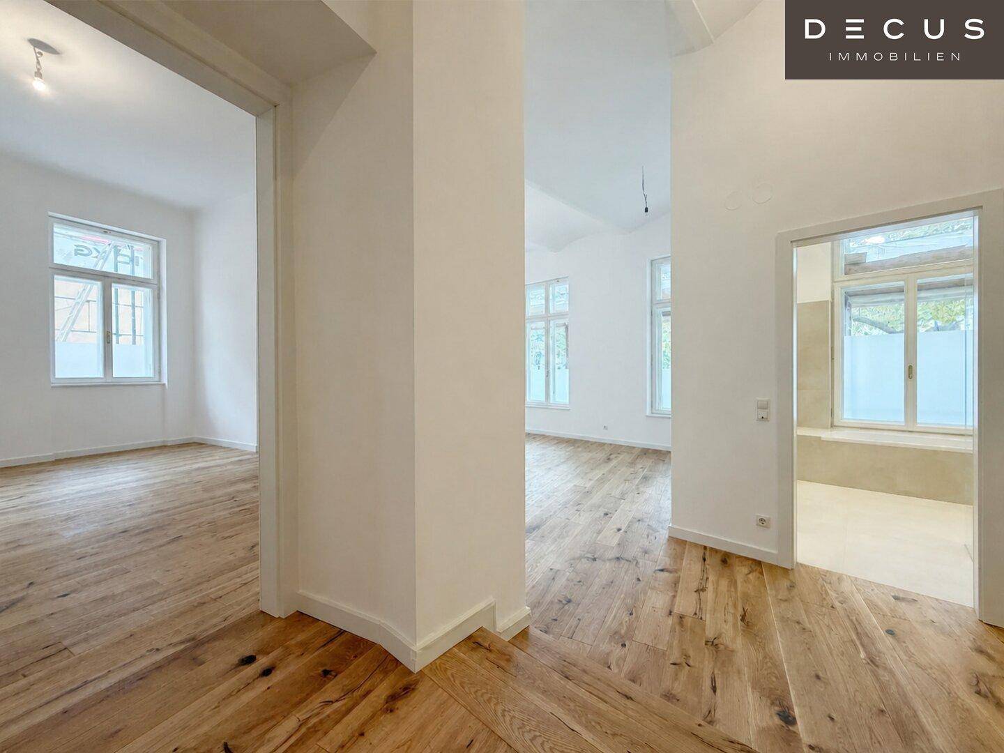 Geräumiger Flur mit Holzboden und Zugang zu verschiedenen hellen Räumen der Wohnung.