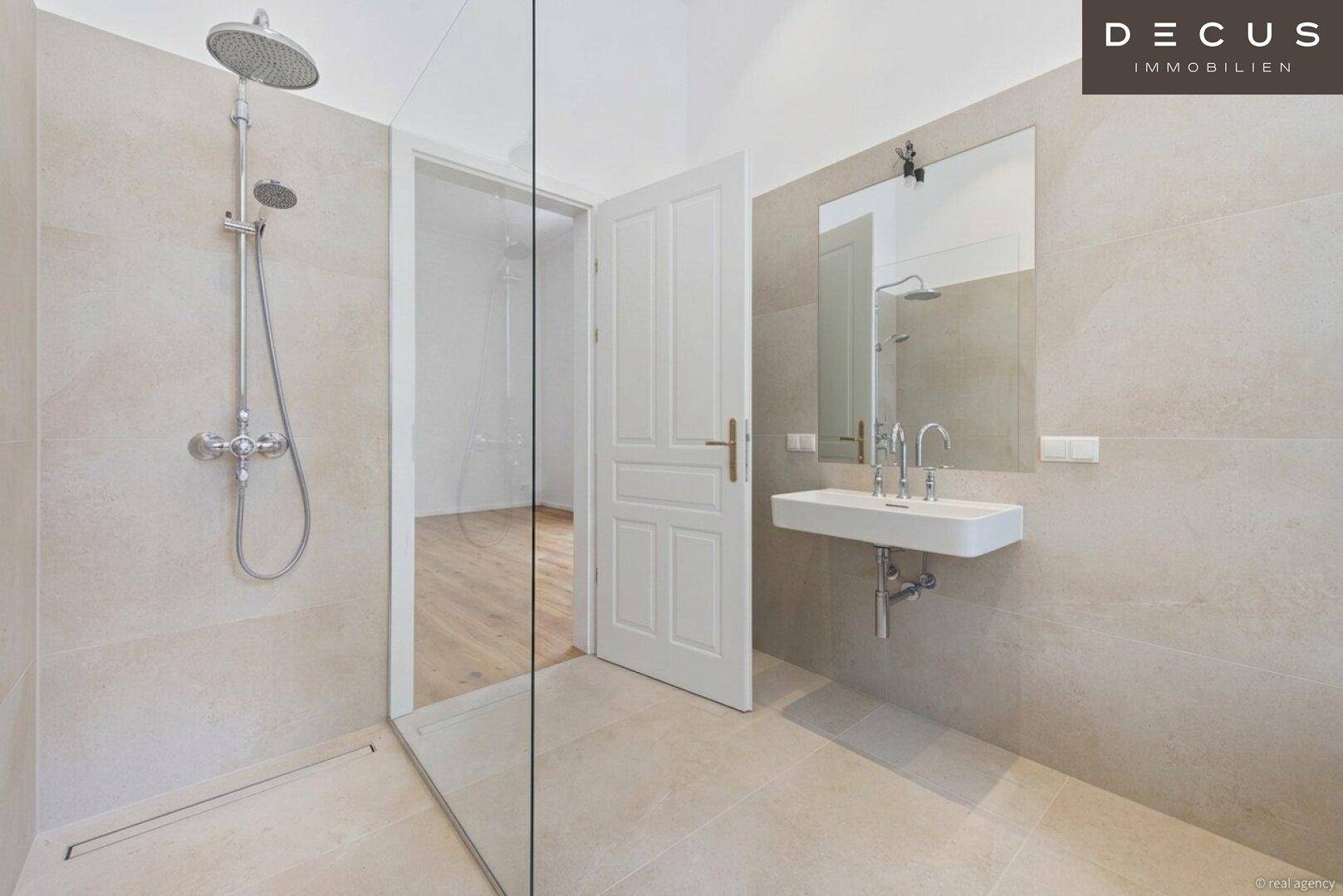 Helles Badezimmer mit modernen Fliesen, Einzelwaschbecken und einer geräumigen begehbaren Dusche.