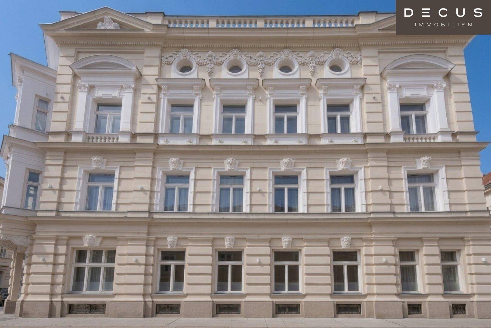 Detailansicht der prunkvollen Fassade eines historischen Gebäudes mit reich verzierten Fenstern.