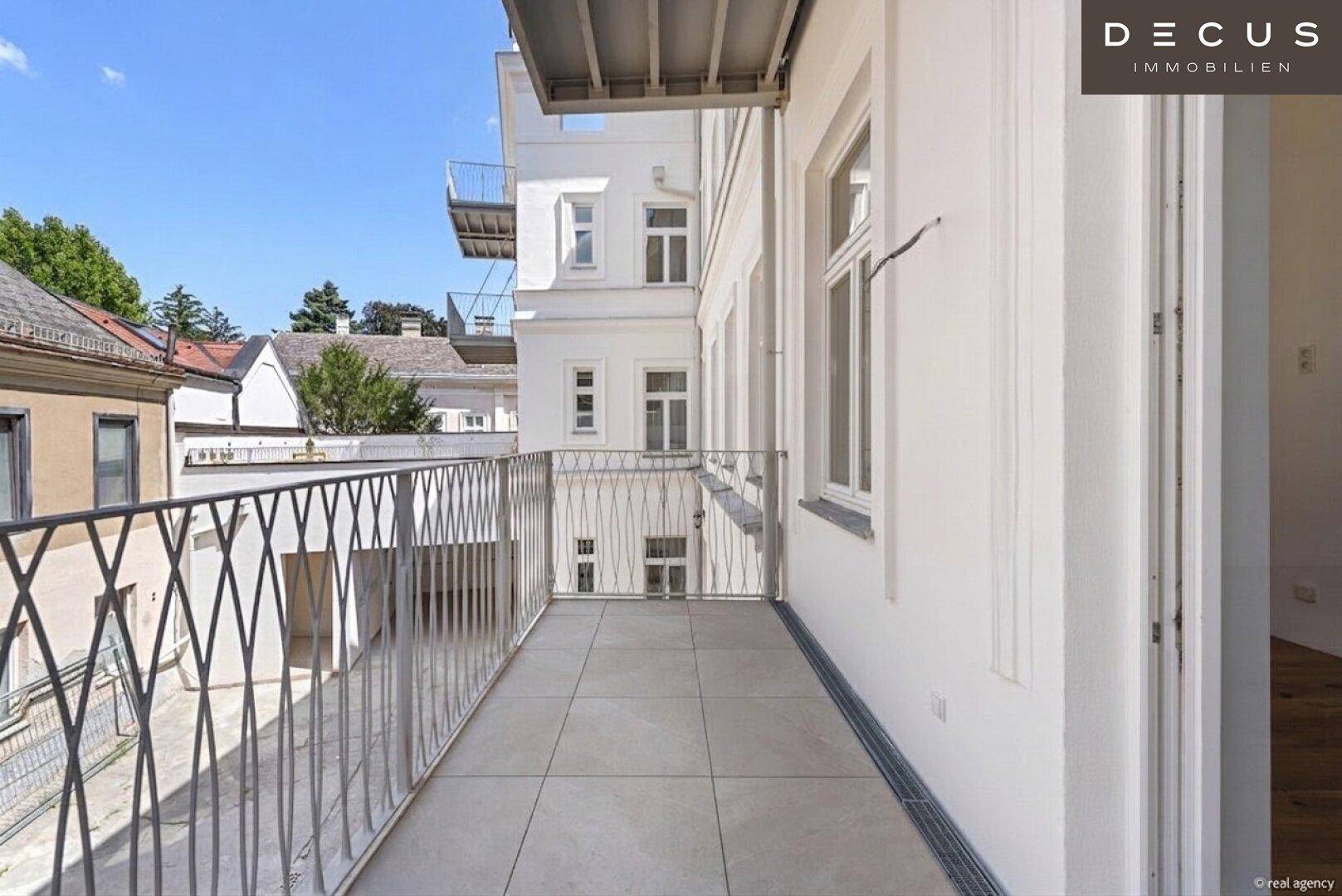 Heller Balkon mit moderner Metallbrüstung und weitem Blick über den ruhigen Innenhof.
