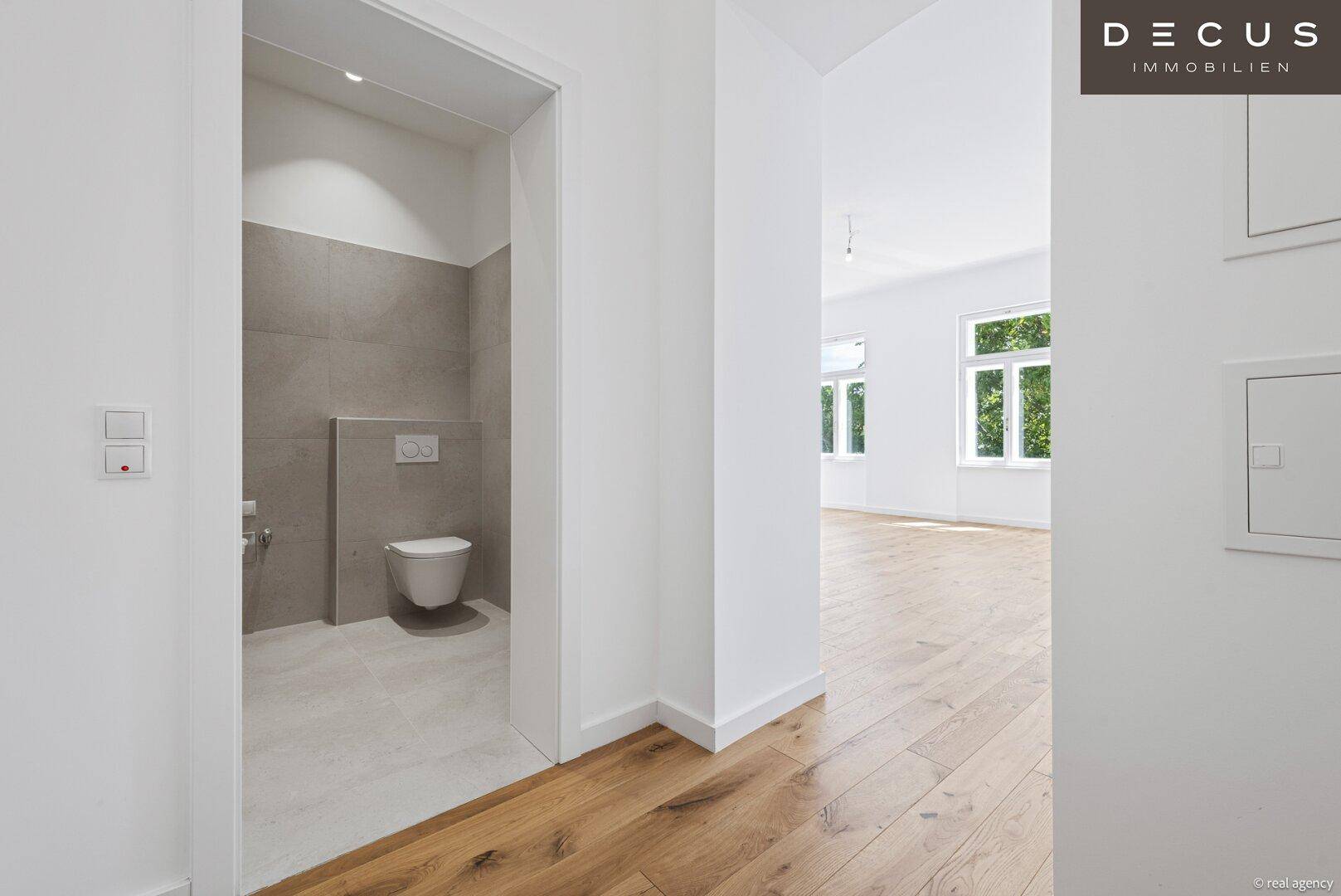 Heller Flur mit Eichenparkett und direktem Zugang zu einer modernen Gästetoilette.
