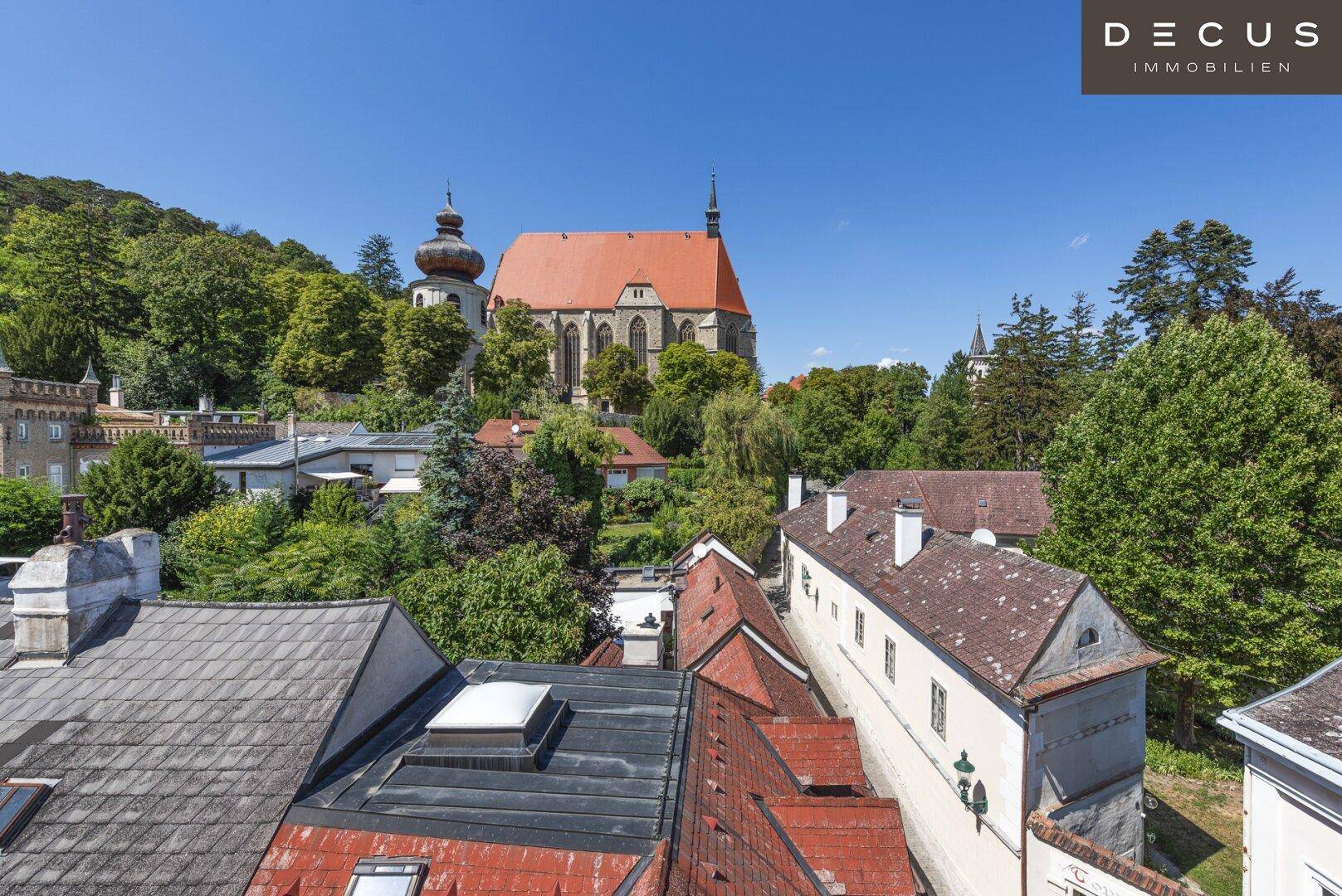 Weitläufiger Ausblick über die historischen Dächer und die beeindruckende Kirche von Mödling.