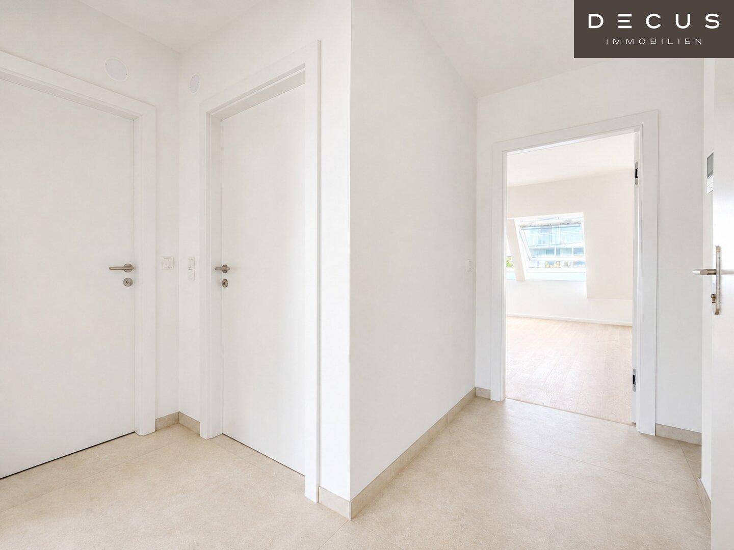 Heller Flur mit Fliesenboden und weißen Türen, der zu verschiedenen Zimmern führt.